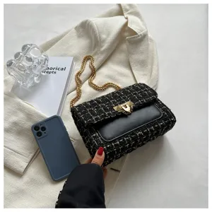 Detailed macro view of black tweed plaid crossbody bag with elegant gold chain strap