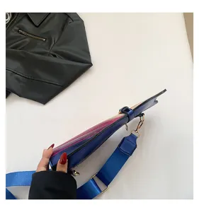 Detail view of colorful gradient crossbody bag with wide blue shoulder strap