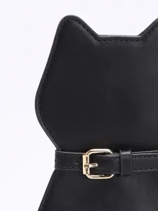 Detail view of a cat-shaped black leather bag with a stylish gold buckle accent