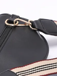 Macro detail of the golden metal hardware clasp and striped shoulder strap texture