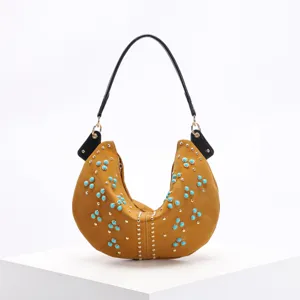 Macro detail of mustard yellow crescent hobo bag decorated with turquoise and gold studs