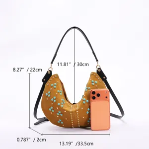 Retro mustard yellow crescent hobo bag with turquoise studs shown with phone for size scale