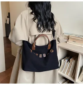 Detail view of the black corduroy tote bag with brown leather handles and casual style.