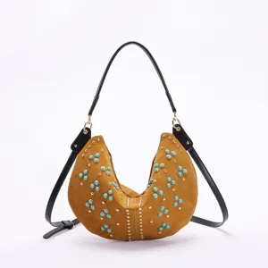 Detailed macro view of a retro moon bag featuring turquoise studs and black leather strap