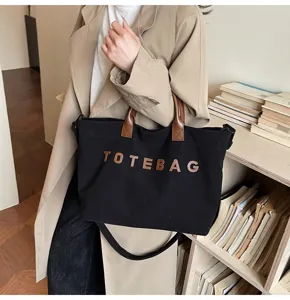 Stylish corduroy tote bag with brown handles and letters detail, perfect for daily commuting use.