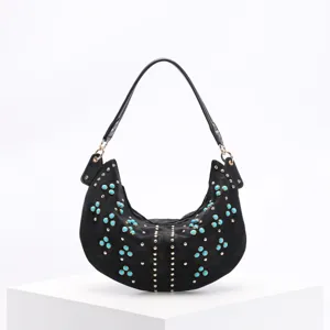 Detailed view of black crescent underarm bag with turquoise beads and gold studs