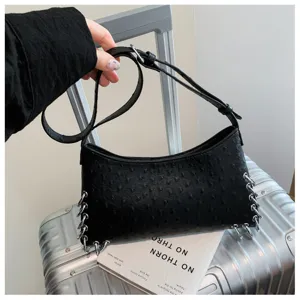 Black punk style underarm shoulder bag with unique metal rings and textured design details.