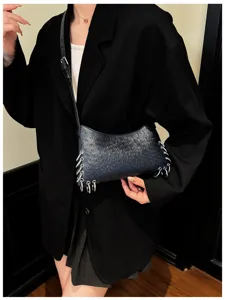 Black punk style shoulder bag for women with metal rings, glossy texture, chic underarm design.