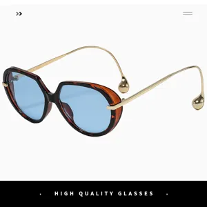 Vue détaillée de lunettes de soleil oversize avec branches fines en métal doré et embouts goutte