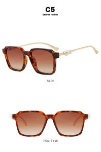 Detailansicht der eckigen Schildpatt-Sonnenbrille mit Goldbügeln und Perlendetails