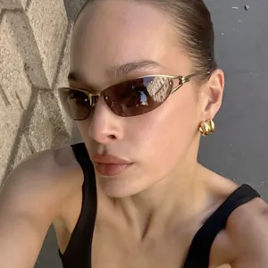 Detailed view of Y2K metal semi-rimless cat-eye sunglasses worn by a model outdoors