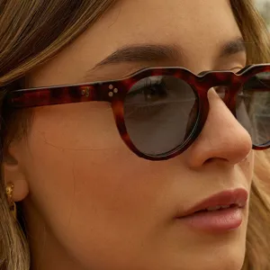 Vista detallada de gafas de sol retro redondas irregulares con montura de carey y puntos