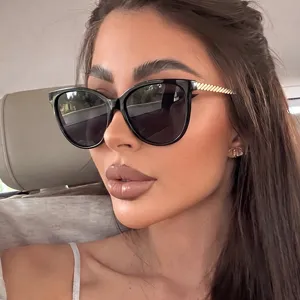 Lunettes de soleil œil de chat rétro pour femmes avec branches dorées côtelées chics.