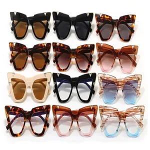 Multiple colors of oversized cat-eye sunglasses with decorative metal studs