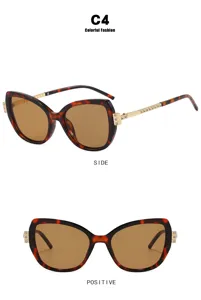 Detail view of cat-eye tortoiseshell sunglasses with rhinestone-encrusted gold temples.