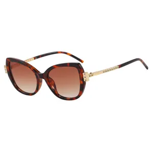 Eleganti occhiali da sole cat-eye tartarugati con stanghette dorate e strass per signora