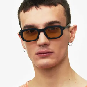 Gros plan détaillé de lunettes de soleil carrées noires avec verres ambrés sur un mannequin