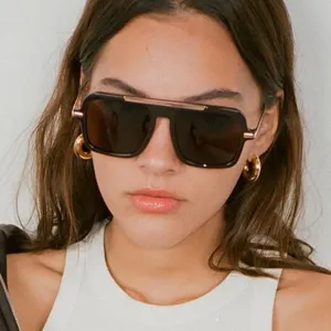 Primo piano di eleganti occhiali da sole squadrati oversize da donna con dettagli in metallo.