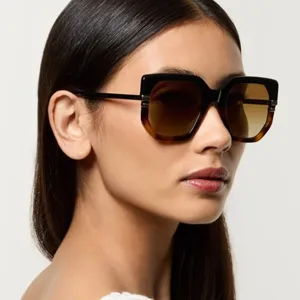 Detailed side view of a model wearing stylish two-tone irregular oversized sunglasses