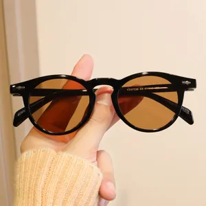 Vue détaillée d'une monture de lunettes ronde noire rétro avec verres teintés bruns
