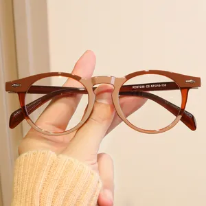 Gros plan détaillé d'une monture de lunettes ronde marron rétro avec clous décoratifs