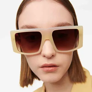 Nahaufnahme eines Models mit modischer, übergroßer, beigefarbener Sonnenbrille und Stil.