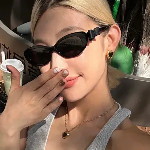 Κοντινό πλάνο κομψών μαύρων γυαλιών ηλίου cat-eye με λεπτομέρειες φιόγκου σε μοντέλο