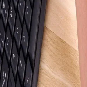 Detaillierte Makroansicht schwarzer mechanischer Tastaturtasten auf einer glatten Holzoberfläche