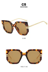 Detail of irregular oversized sunglasses with leopard print frames and gold temples.