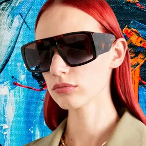 Close-up detail showing the oversized square tortoise shell sunglasses on a fashion model