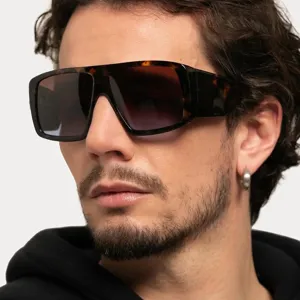 Close-up of oversized square tortoise-shell sunglasses with gradient lenses for men.