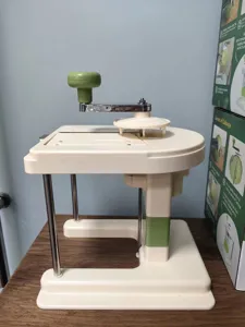 Side view of a manual household cabbage shredder featuring a green crank and sturdy base