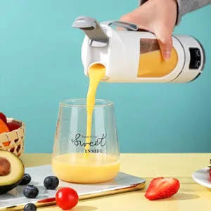 Portable rechargeable electric juicer cup pouring fresh orange juice into a glass