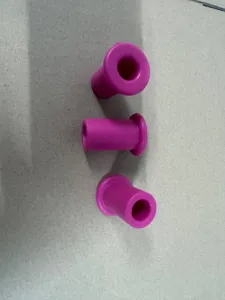 Macro detail view of three magenta silicone pastry corer plugs on a plain gray background