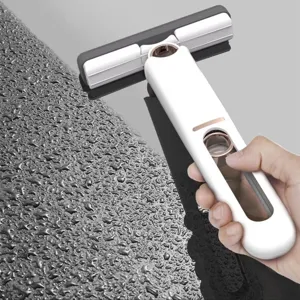 Close-up of handheld mini sponge mop cleaning water droplets on a smooth surface