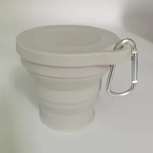 Primo piano di una tazza da viaggio pieghevole in silicone grigio con moschettone