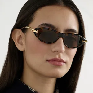 Close-up van een trendy cat-eye zonnebril in schildpadstijl met gouden kettingschakels