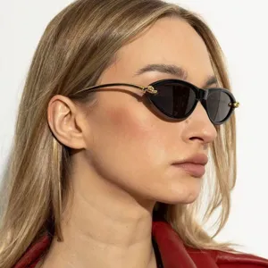 Detailweergave van een zwarte retro cat-eye zonnebril met gouden metalen pootjes