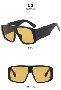 Detailed view of oversized square sunglasses with orange lenses and thick black frames