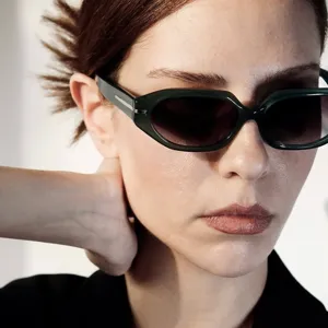 Detailed close-up of fashion-forward irregular small frame sunglasses on a model.