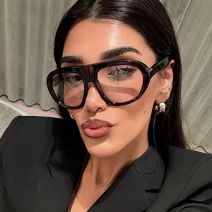 Dettaglio di occhiali da sole aviator oversize alla moda con montatura tartarugata su modella