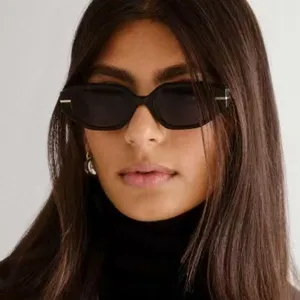 Close-up of female model wearing irregular small frame black sunglasses for fashion