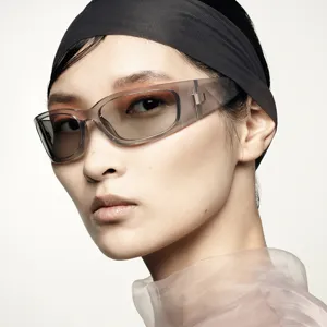 Detailed macro shot of Y2K sports sunglasses featuring grey translucent frames on a fashion model
