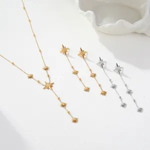 Detail view of gold and silver stainless steel starburst tassel necklace and earrings set