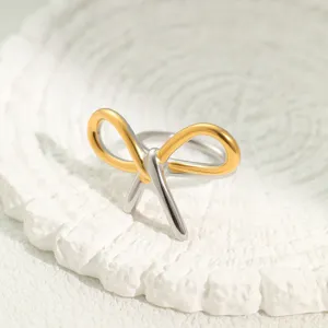 Nahaufnahme des gold- und silbernen zweifarbigen Knotenbogenrings auf strukturiertem Stein