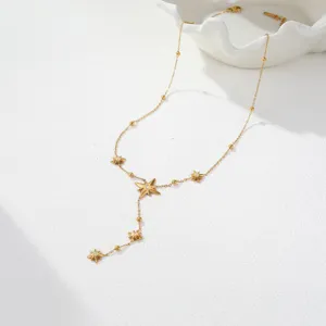 Close-up detail of a gold-plated stainless steel necklace featuring elegant star motifs