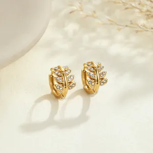 Close-up detail of gold-plated stainless steel leaf hoop earrings with rhinestones