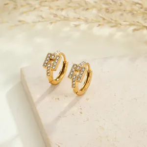 Close-up of gold-plated stainless steel hoop earrings with sparkling crystal accents