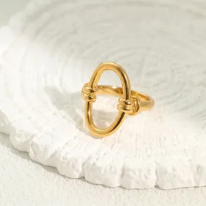 Detailansicht des verdrehten Knotens und des goldenen ovalen Designs auf dem Edelstahlring