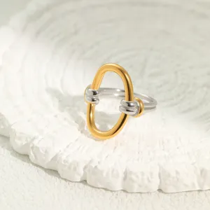 Detailaufnahme eines zweifarbigen Edelstahl-Knotenrings auf strukturierter Platte